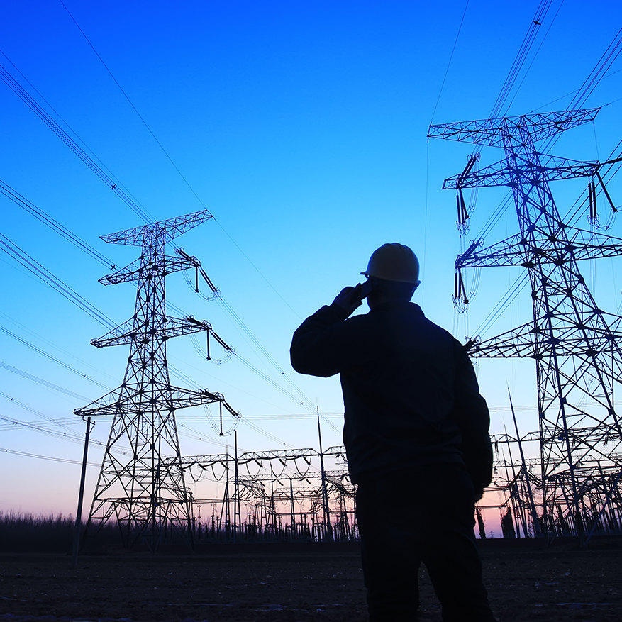 Electricity workers and pylon silhouette