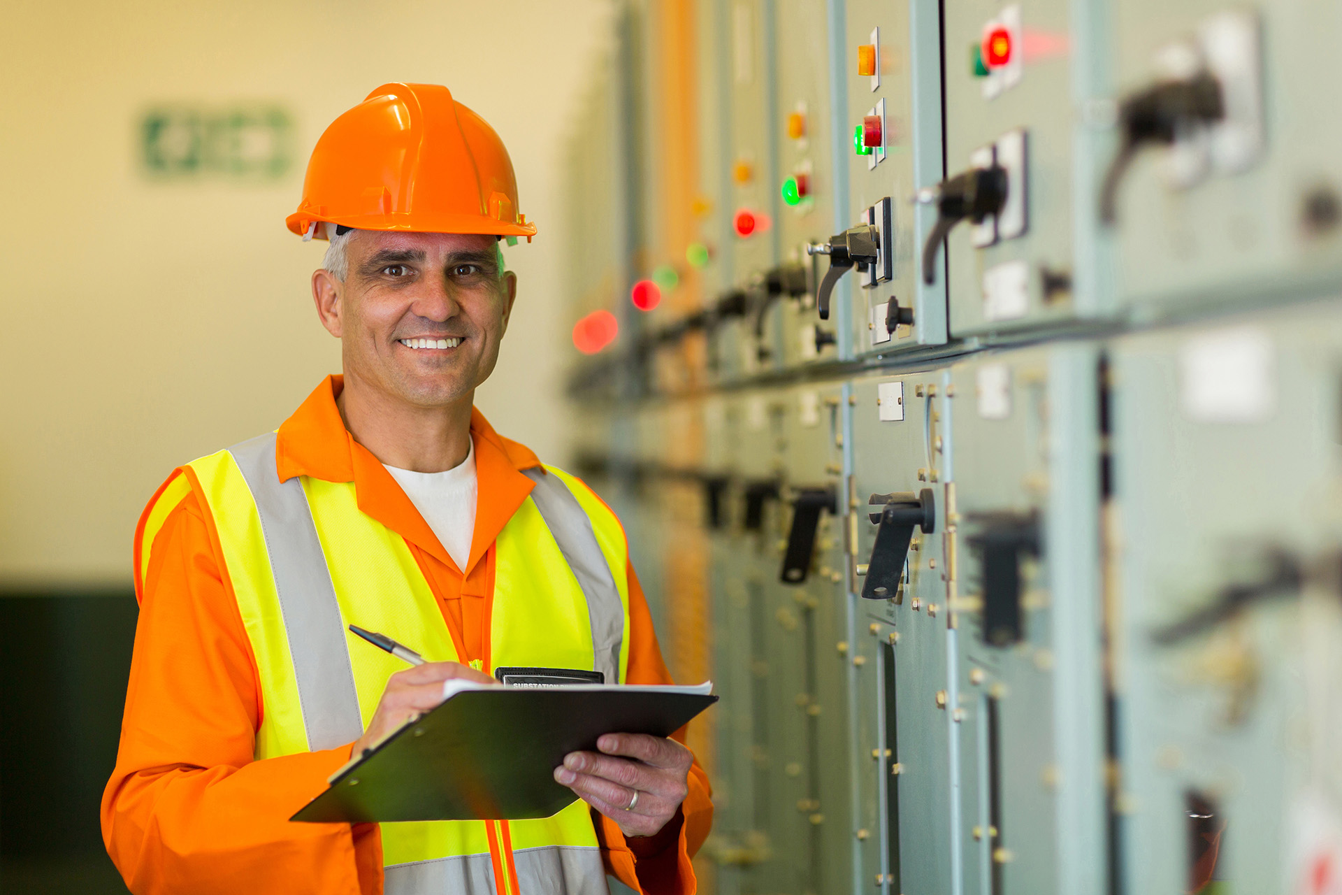 mature electrician working in control room